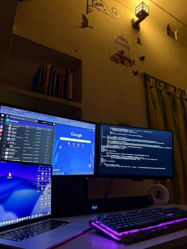 Juwel Rana's workspace — multi-monitor setup with RGB keyboard